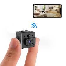 a hand holding a small camera with an image of a living room in the background