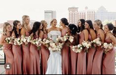 a group of women standing next to each other holding bouquets in front of them