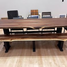 a wooden table with two benches in front of it on top of a hard wood floor