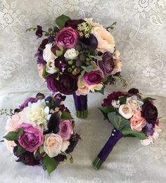 the bridal bouquets are laid out on the lace tablecloth, with purple and white flowers