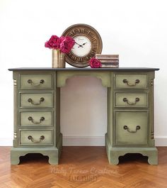 a green desk with drawers and a clock on top