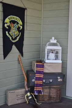 harry potter banner hanging on the side of a house next to luggage and an umbrella