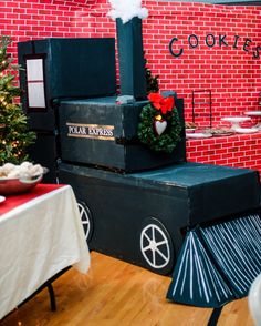 a black cart with christmas wreaths on it in front of a brick wall and wooden floor