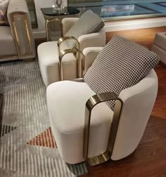 a living room filled with white couches and chairs on top of a wooden floor