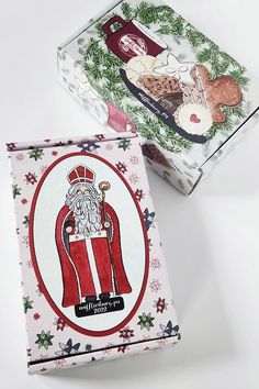 two boxes with christmas designs on them sitting next to each other, one has a santa clause and the other has a snowman