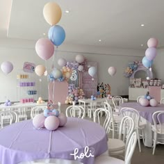 there are many balloons in the air at this birthday party with purple, blue and white colors