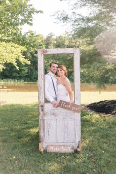 a bride and groom pose in an old door for their wedding photo shoot at the park