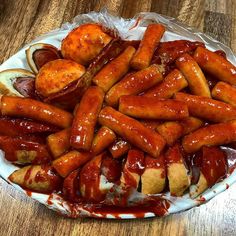 hot dogs and buns covered in ketchup on a plate