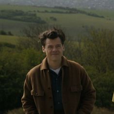 a man standing on top of a lush green hillside