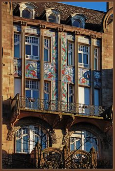 an ornate building with many windows and balconies on the second floor, painted in multicolors