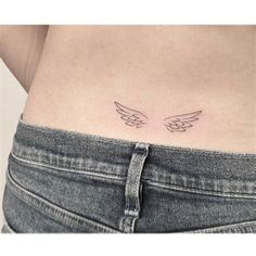 an angel wing tattoo on the back of a woman's stomach