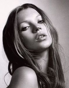 a woman with long hair is posing for a black and white photo, her eyes are half closed