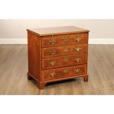 an antique chest of drawers with brass hardware on the top and bottom, in a room