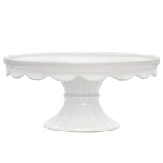 a white cake plate with scalloped edges on an isolated pedestal, set against a white background