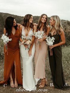 four bridesmaids standing together in the desert with their bouquets smiling at each other