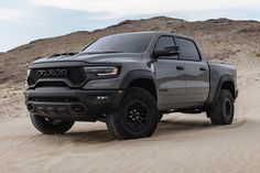 a gray ram truck driving through the desert