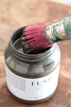 a paint brush is in a jar on a table