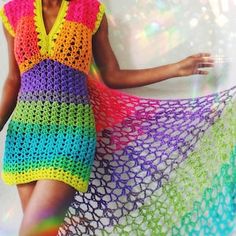 a woman in a colorful crochet dress poses for the camera