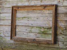 an old wooden frame hanging on the side of a building