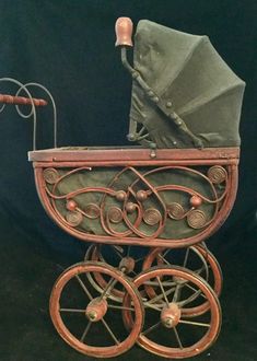 an old fashioned baby's pram is displayed on a black background with red wheels