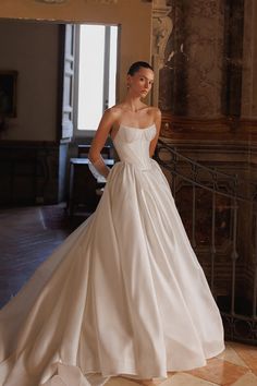 a woman in a white wedding dress posing for the camera