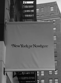 a large sign hanging from the side of a building in new york city, ny