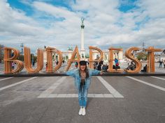 a woman standing in front of the words buddist with her arms up and hands behind her head