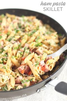 a skillet filled with pasta and vegetables