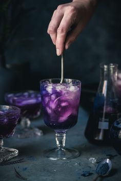 a person is pouring purple liquid into a cocktail glass with the words polyjuice portion cocktail