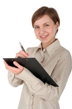 a woman holding a clipboard and a knife in one hand while smiling at the camera