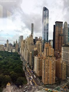 an aerial view of a city with tall buildings and cars on the street in front of it