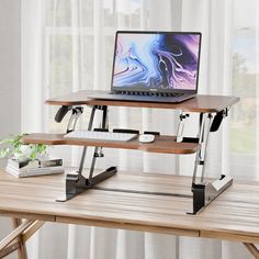 a laptop computer sitting on top of a wooden desk next to a window with curtains