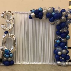 a balloon arch decorated with blue and silver balloons