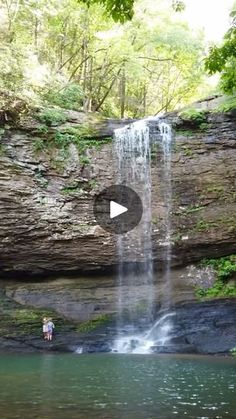 a waterfall with people standing in the water