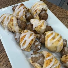 a white plate topped with meatballs covered in icing