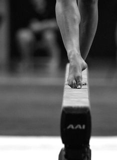 black and white photograph of a person standing on a bench with their feet in the air