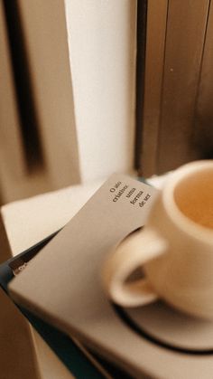 a cup of coffee sitting on top of a table next to a stack of papers