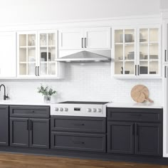 a white and black kitchen with wood floors