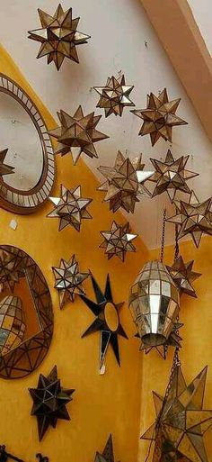 many stars are hanging on the wall in front of mirrors and other decorative items,