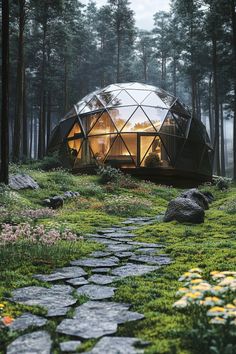 a glass dome in the middle of a forest with flowers and rocks on the ground