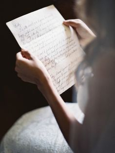 a woman holding a piece of paper with writing on it