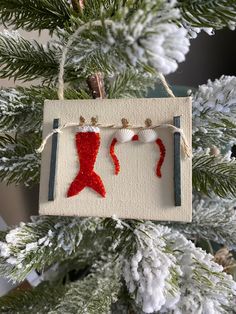 an ornament hanging from a christmas tree decorated with red sequins and twine