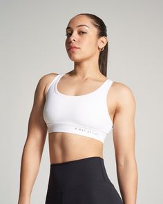 A confident young woman poses in a fitted white sports bra and high-waisted black leggings highlighting her athletic build against a minimalistic background Sports Bra Design, Medium Support Sports Bra, Wrestling Shoes, Bra Models, Support Bra, White Sports Bra, Team Gear, Female Wrestlers, Stay Active