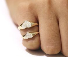 a woman's hand with two gold rings on top of it and one diamond in the middle