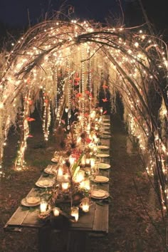 an outdoor dinner table with candles and lights