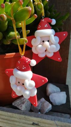 two christmas decorations are hanging from a plant