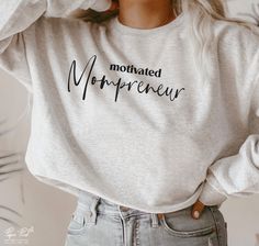 a woman wearing a white sweatshirt with the word mohnated morpacreu printed on it