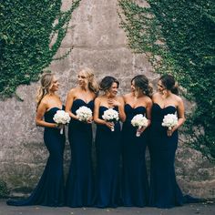 the bridesmaids are all dressed in navy blue dresses