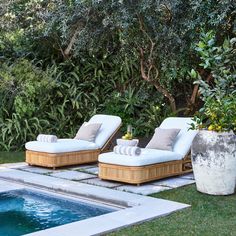 two chaise lounge chairs next to a swimming pool