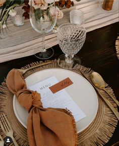 a place setting with napkins, silverware and wine glasses